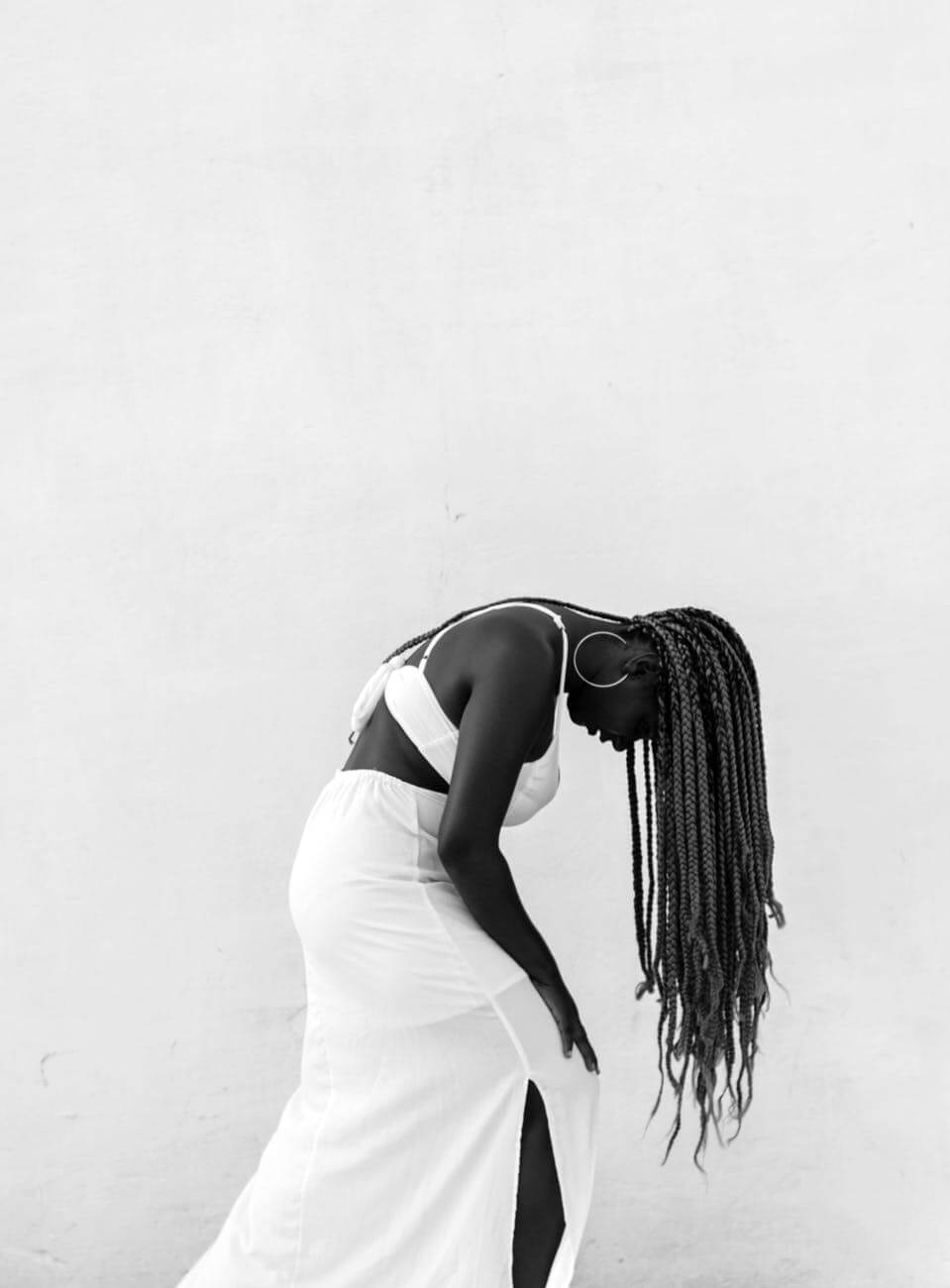 woman wearing white dress bending down