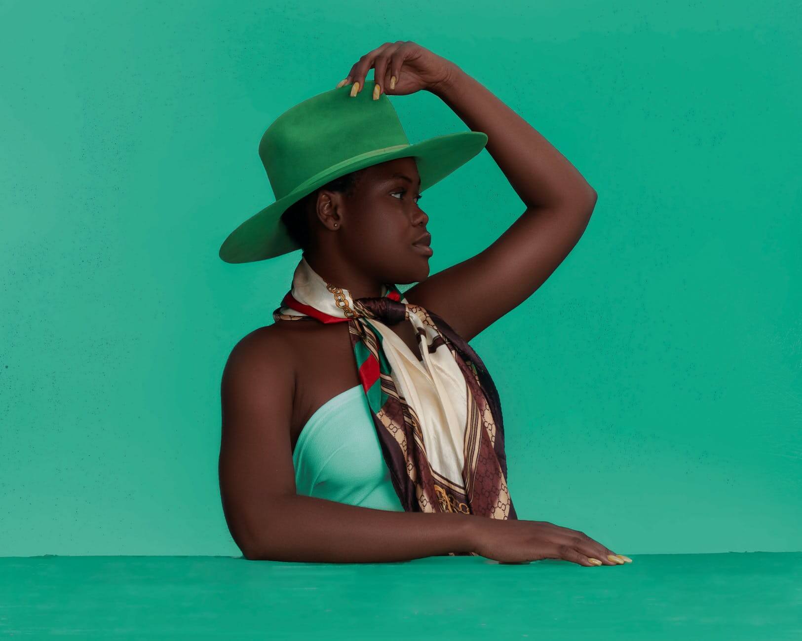 stylish black woman in hat looking away