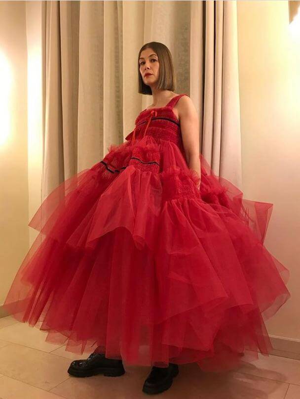 Rosamund Pike un vestido rojo con mucho volumen de corte midi y unos borcegos negros golden globes 2021